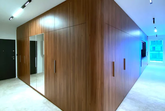 Full-height walnut veneer wardrobe with rounded corners and continuous wood grain in modern interior