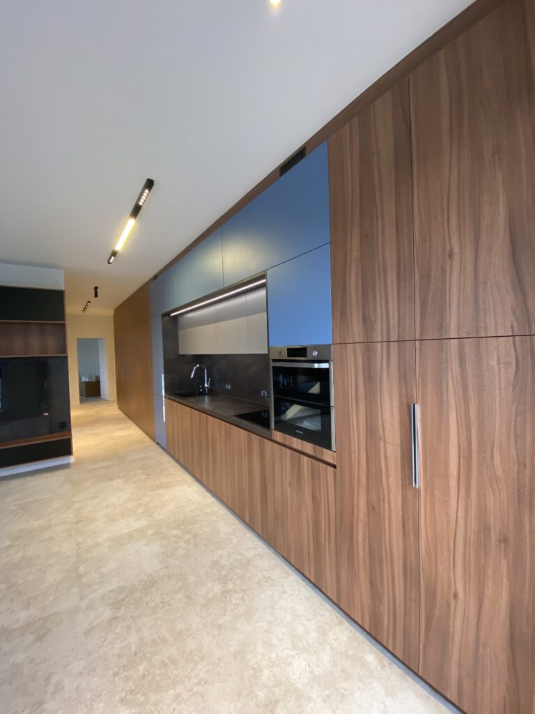 Walnut veneer kitchen cabinetry with integrated appliances Seamless walnut veneer kitchen cabinetry with integrated appliances and handle-less design